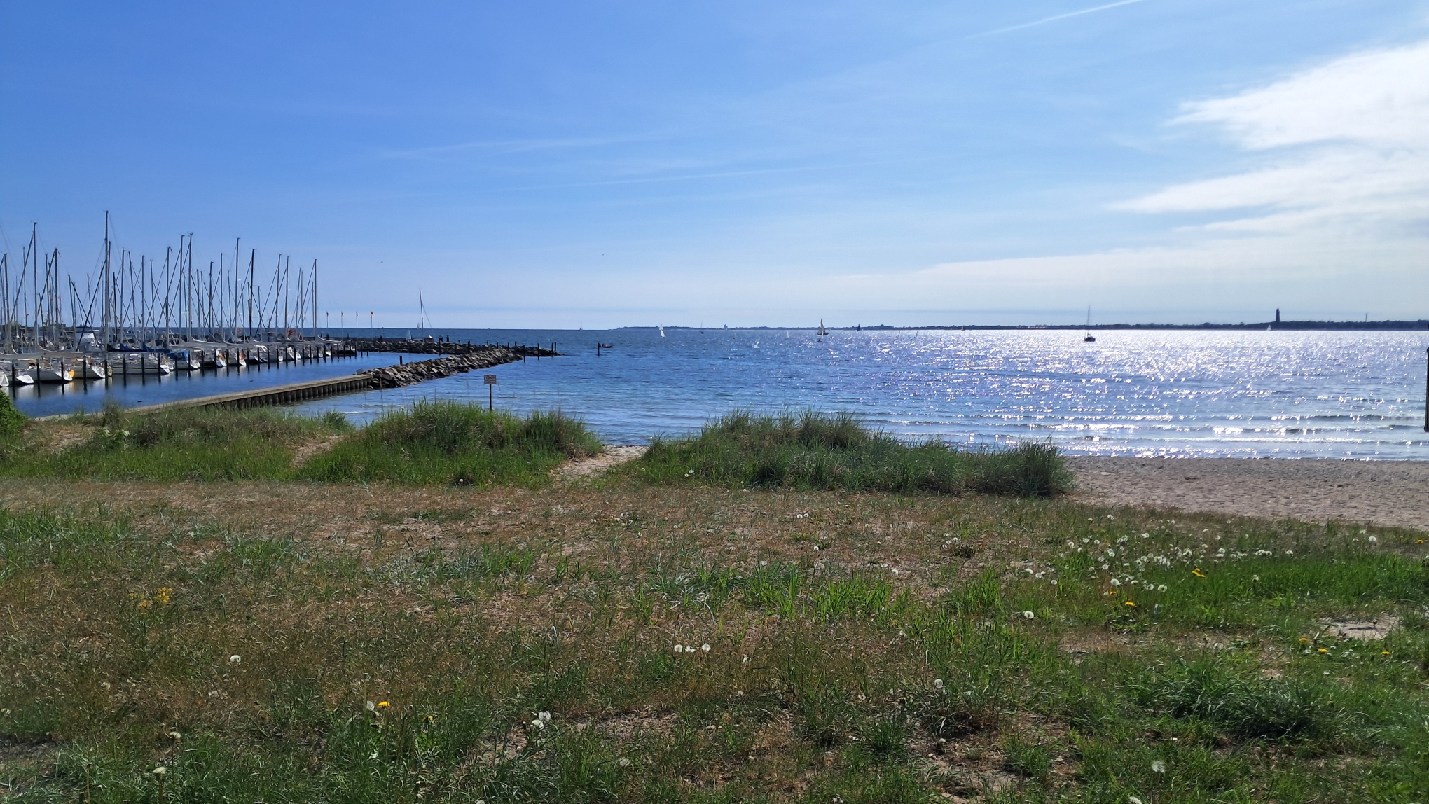 Foto der Strander Bucht bei sonnigem Wetter mit dem Yachthafen am linken Bildrand